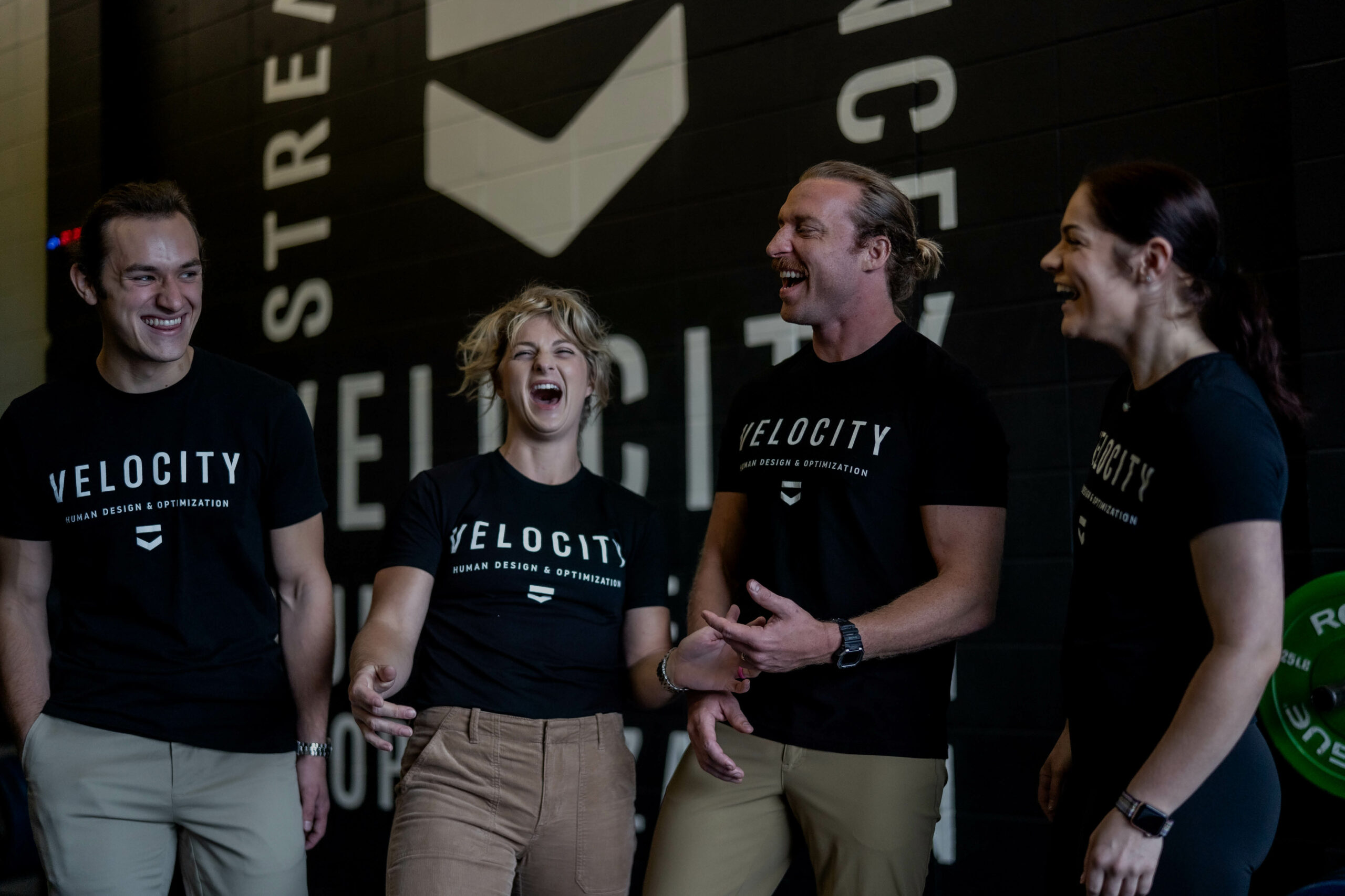 4 people wearing velocity t-shirts smiling and laughing